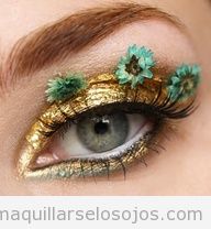 Maquillaje de ojos dorado con flores en las pestañas
